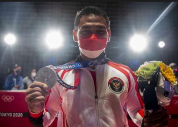 Lifter Indonesia Eko Yuli Irawan menunjukkan medali perak kelas 61kg Putra Grup A Olimpiade Tokyo 2020 di Tokyo International Forum, Tokyo, Jepang, Minggu (25/7/2021). Eko Yuli berhasil mempersembahkan medali perak dengan total angkatan 302kg. (ANTARA FOTO/SIGID KURNIAWAN)