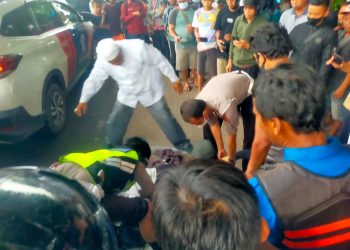 Pihak Kepolisian dibantu warga mengevakuasi seorang mahasiswi tewas terlindas truk