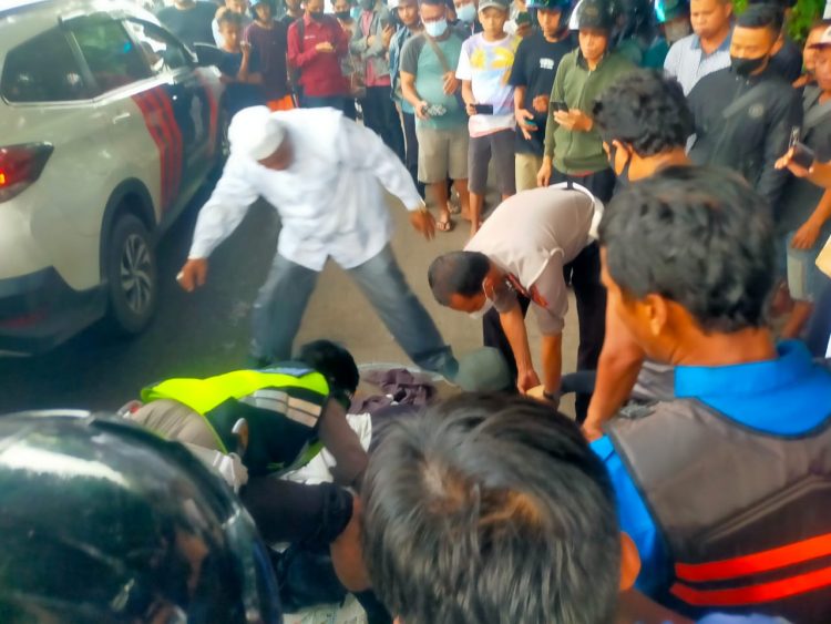Pihak Kepolisian dibantu warga mengevakuasi seorang mahasiswi tewas terlindas truk