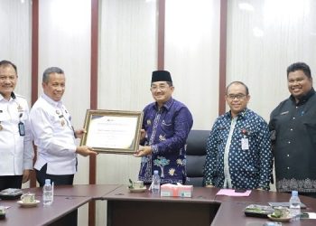 Bupati Tanjungjabung (Tanjab) Barat, Anwar Sadat, saat menerima penghargaan dari Kepala Kantor Kemenkumham Wilayah Jambi, Kamis (19/1). Foto: Wahyu