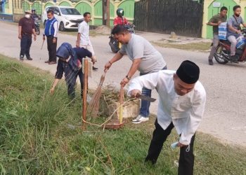 M. Umar dan Kabid GTK Disdik Jambi saat ikut berpartisipasi gotong royong di arena pembukaan STQ. Foto: Dok BTIKP Disdik Jambi