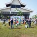 SUMATRA – Dalam rangka memperingati Hari Ulang Tahun (HUT) ke-65 bertema “The
New Horizon” dan peringatan Hari Bumi 22 April 2026, Hutama Karya menyelenggarakan aksi penanaman pohon secara serentak di seluruh ruas Jalan Tol Trans-Sumatera (JTTS) yang dikelola. Kegiatan ini sekaligus menjadi kick-off program penanaman 17.000 pohon dari 18 jenis tanaman di 11 ruas tol di JTTS yang dikelola di sepanjang tahun 2026 ini. Adapun jenis pohon yang ditanam disesuaikan dengan kondisi dan jenis tanah di daerah masing-masing. Aksi ini sejalan dengan arahan Kementerian Lingkungan Hidup yang pada tahun 2025 mengajak seluruh pengelola jalan tol di Indonesia untuk menghijaukan koridor dan mengendalikan emisi di kawasan jalan tol. Sebagai pengelola JTTS, Hutama Karya menjadikan penghijauan sebagai bagian dari tanggung jawab pengelolaan infrastruktur. “Di Usia ke-65, Hutama Karya ingin menunjukkan bahwa Pembangunan infrastruktur dan tanggung jawab lingkungan bukan hal yang bertentangan, tema “The New Horizon” bagi kami salah satu wujudnya adalah komitmen nyata terhadap penghijauan di koridor JTTS,” ujar Iwan Hermawan, Direktur Operasi III Hutama Karya. Program penghijauan di Rest Area dan Ruang Milik Jalan (Rumija) JTTS bukan kegiatan baru. Hutama Karya telah menjalankan penanaman pohon secara bertahap sejak beberapa tahun terakhir, seiring dengan beroperasinya ruas-ruas tol baru di Sumatra. “Hingga saat ini, sekitar 98.000 pohon telah tumbuh di sepanjang koridor JTTS. Pohon yang ditanam dipilih berdasarkan kesesuaian dengan ekologi kawasan setempat, dan berfungsi tidak hanya sebagai penghijauan tetapi juga untuk menjaga kualitas udara, meredam kebisingan, mencegah erosi tanah, serta meningkatkan kenyamanan pengguna jalan,” tambah Iwan. Penanaman pohon ini dilaksanakan secara serentak di seluruh ruas JTTS yang dikelola Hutama Karya. Sementara itu, seremoni utama kegiatan dilaksanakan di Rest Area KM 41 Jalur B Tol Binjai–Langsa, yang ditandai dengan penanaman pohon oleh Direktur Operasi III Hutama Karya Iwan Hermawan bersama jajaran manajemen Hutama Karya dan Panitia HUT HK
lainnya. Kegiatan tersebut turut dihadiri oleh Ketua Tim Jalan Bebas Hambatan BBPJN Sumut Sriono, Kepala Satuan PJR AKBP Dhery Fajariandono, dan Kepala Dinas Perhubungan Kabupaten Langkat Arie Ramadhany sebagai bentuk dukungan terhadap upaya penghijauan di koridor JTTS. Langkah Awal: Mengukur Dampak Lingkungan Khusus tahun ini, Hutama Karya melakukan pengukuran potensi serapan karbon dari vegetasi
yang ditanam di koridor JTTS. Menggunakan pendekatan perhitungan berbasis The Intergovernmental Panel on Climate Change (IPCC), 17.000 pohon yang ditanam pada tahun 2026 diproyeksikan mampu menyerap sekitar 9.930 ton CO2e secara kumulatif hingga tahun 2050. “Angka-angka ini belum pernah dipublikasikan sebelumnya dan untuk pertama kalinya, kontribusi ekologis nyata diukur dengan metode sains dapat dibagiakan kepada publik, yang penting bagi kami adalah mulai mengukur, apa yang bisa diukur agar dapat dikelola dan ditingkatkan, ini baru awal dan angka ini akan terus bertambah seiring berjalannya operasional JTTS,” imbuh Iwan. Penghijauan sebagai Bagian dari Pengelolaan Infrastruktur Jalan Tol Dengan puluhan ribu pohon yang kini tumbuh di sepanjang Rumija dan Rest Area, Hutama Karya memandang penghijauan sebagai bagian yang tidak terpisahkan dari pengelolaan infrastruktur jalan tol. Inisiatif ini bukan sekadar program tambahan, melainkan salah satu komponen
penting dalam operasional jalan tol yang berkelanjutan. Koridor JTTS tidak hanya berfungsi sebagai jalur konektivitas ekonomi di Sumatra, tetapi juga diharapkan dapat memberikan manfaat ekologis bagi kawasan yang dilaluinya. “Ke depan, Hutama Karya akan terus memperluas cakupan penghijauan seiring dengan
pertumbuhan jaringan JTTS serta mempublikasikan perkembangan data dampak lingkungan secara berkala sebagai bentuk akuntabilitas kepada public,” tutup Iwan. Sebagai tambahan informasi, program Hutama Karya ReGreen merupakan bagian dari rangkaian Hutama Karya Peduli, yaitu program Tanggung Jawab Sosial dan Lingkungan (TJSL) yang dirancang untuk menciptakan nilai bersama,tidak hanya bagi perusahaan, tetapi juga bagi masyarakat dan lingkungan. Selain ReGreen, program ini juga mencakup Hutama Karya Mengajar, Hutama Karya EduInfra, Hutama Karya WASHInfra, serta Bazaar UMKM. Selain itu, penanaman pohon lainnya juga dilaksanakan di ruas tol yang berada di Pulau Jawa yakni Tol Akses Tanjung Priok (ATP) dan JORR Seksi S (JORR-S).